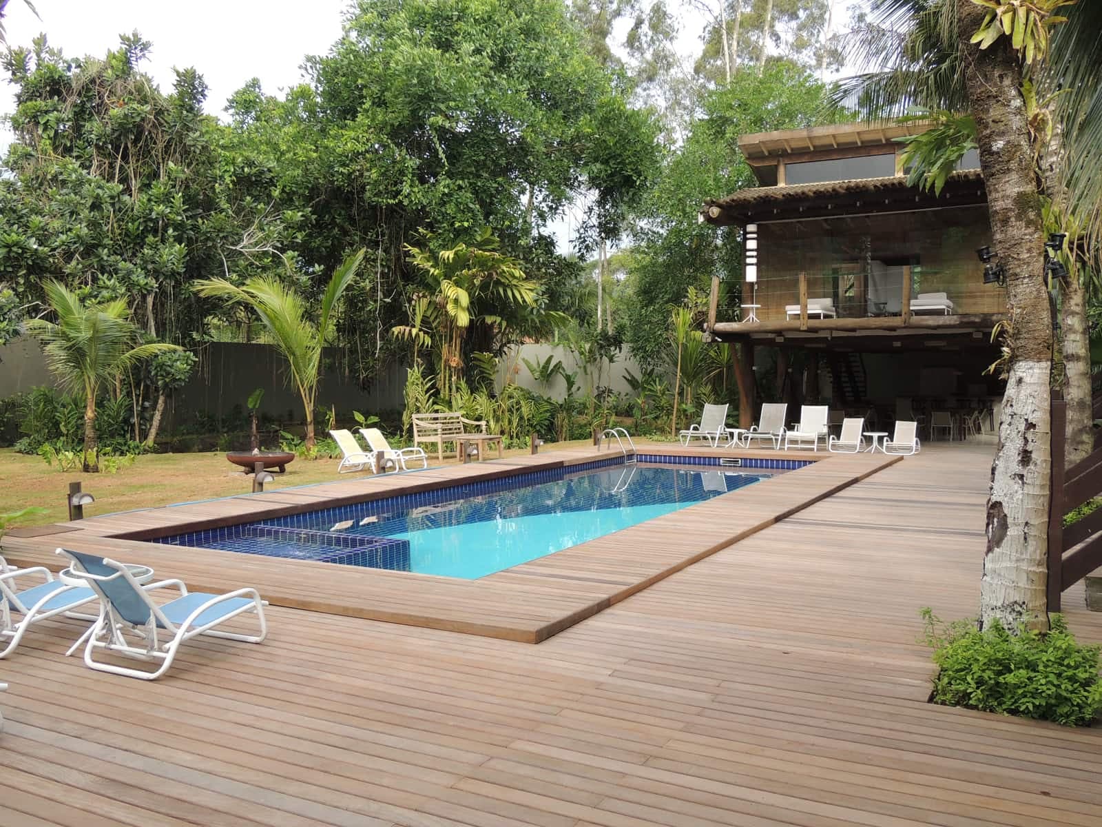 Piscina e área comum do Flat Camburi, cercada por vegetação